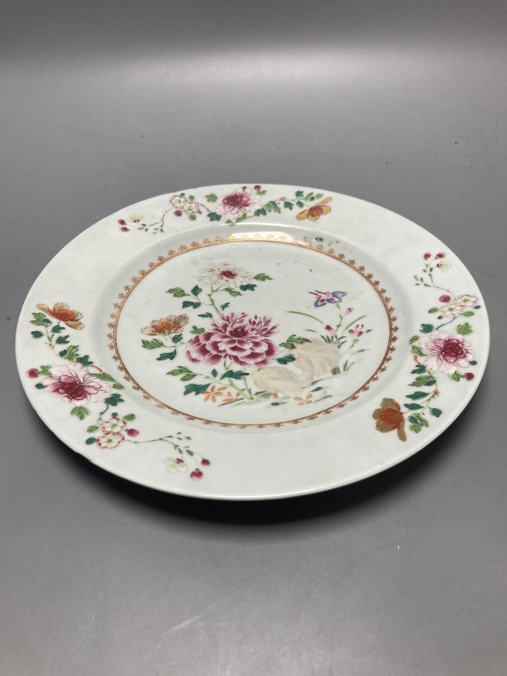 An 18th century Chinese famille rose plate together with a Chinese blue and white plate and a famille rose mug lacking handle, largest